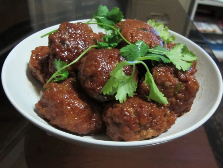 a white bowl filled with meat and garnish