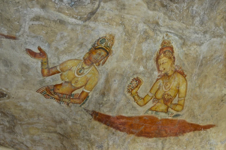 two paintings painted on a wall in a cave