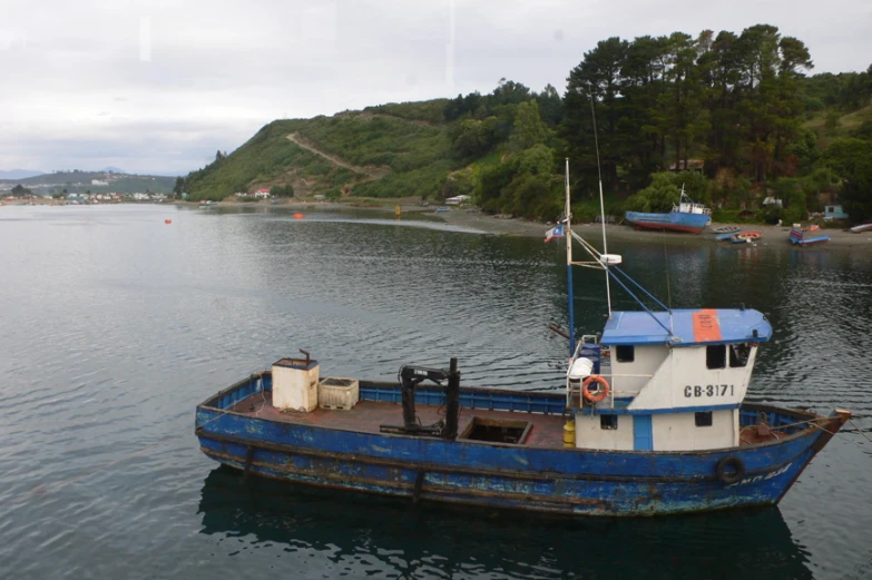 a small blue and white boat floating on top of a body of water