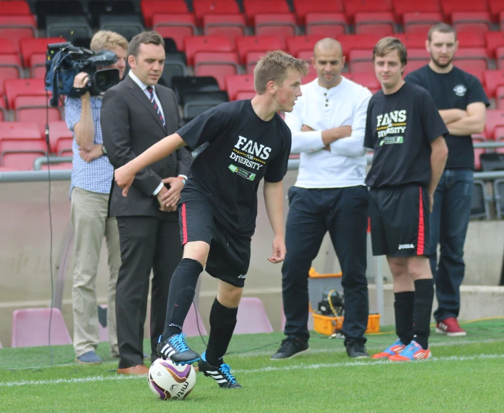 soccer player on field with camera next to empty seats