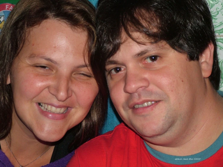 a couple posing for a po together on a red and blue cloth