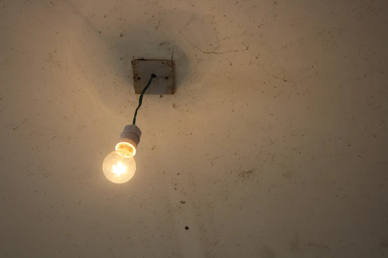 a light bulb suspended off the side of a wall