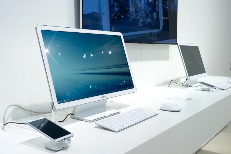 three monitors that are sitting on a desk