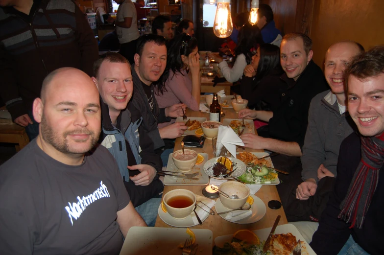 a group of people sitting at a long table