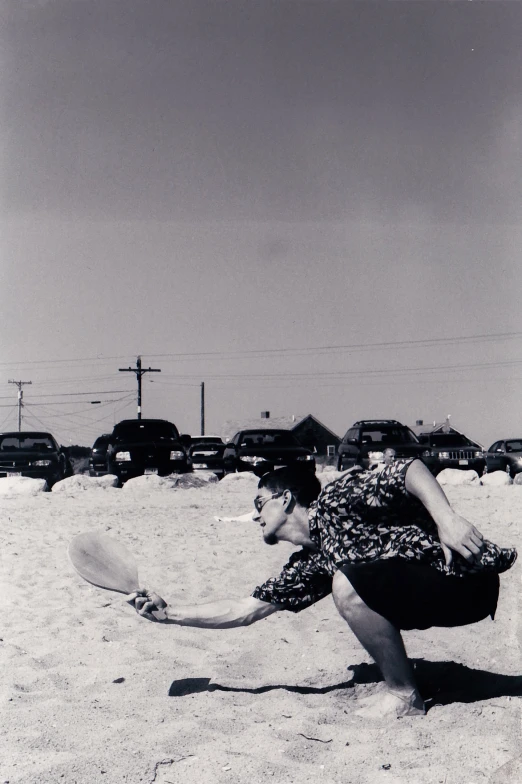 a woman is playing frisbee on the beach