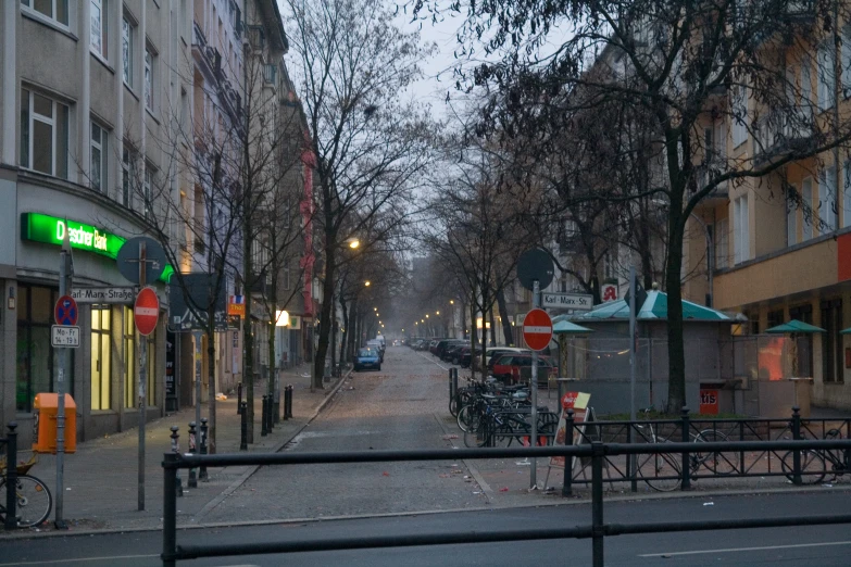 an empty street with bikes, people and buildings on either side