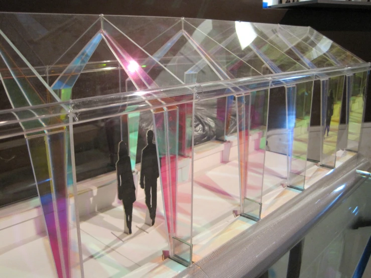 several people walk through a transparent glass display