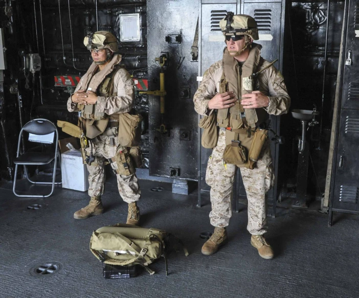 two soldiers stand in front of the door of a room with a large machine on it