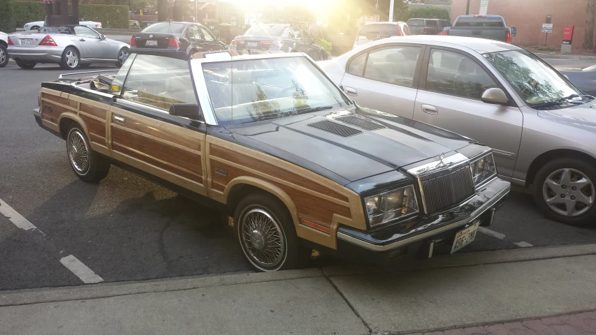 an old station wagon in a parking space near many other vehicles