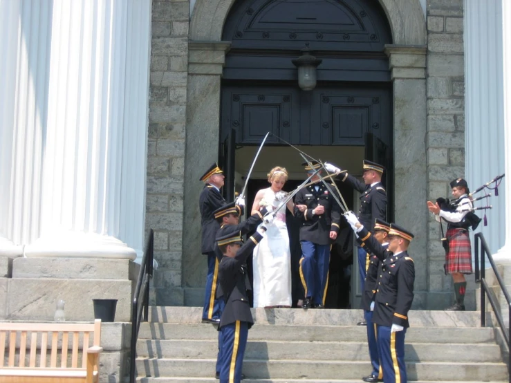 several soldiers stand by the door of a building, and prepare to perform