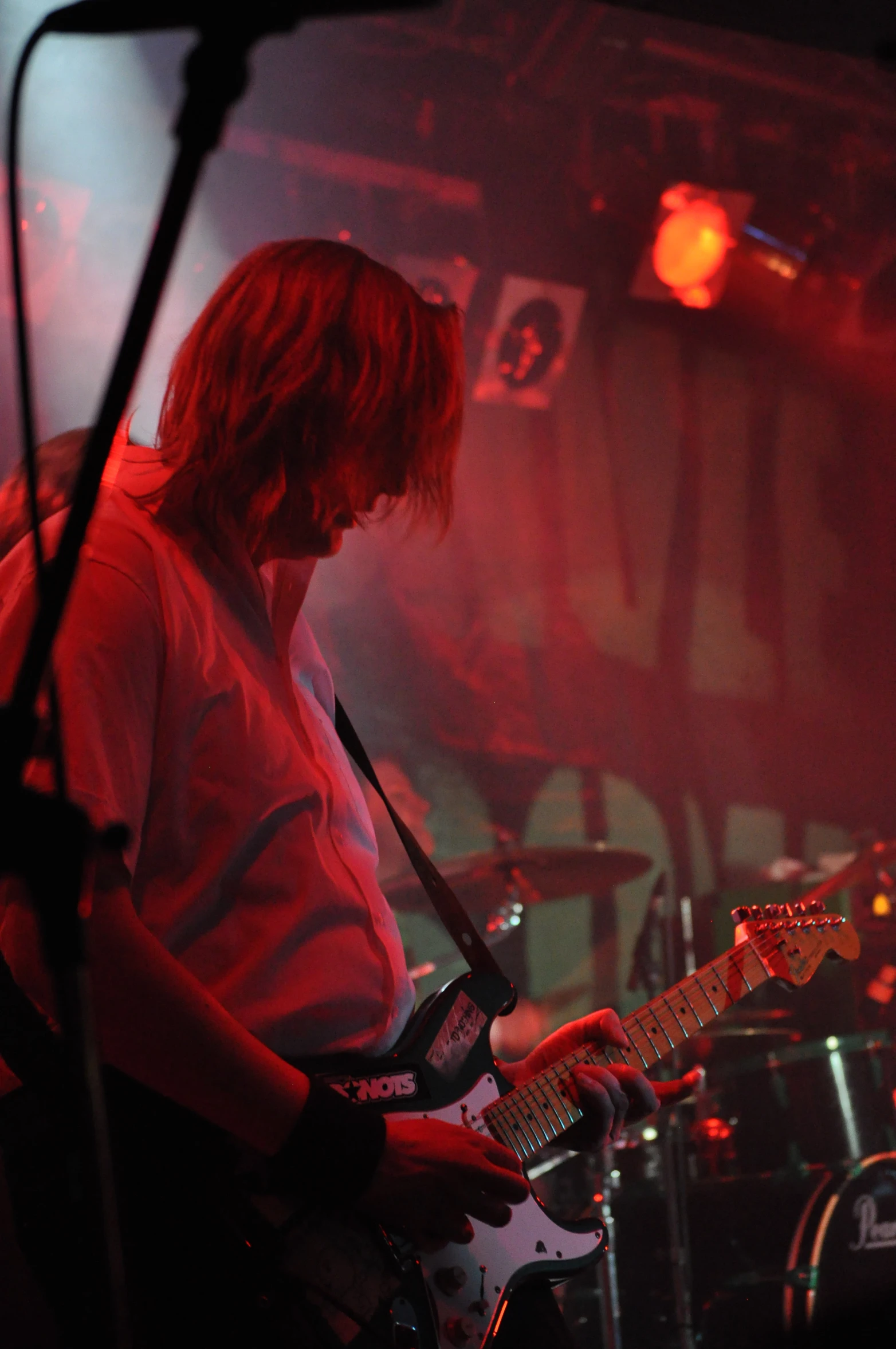 man on stage playing guitar and singing into the microphone