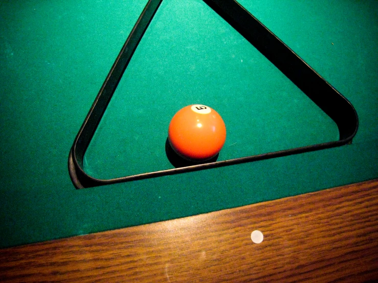 pool ball inside of triangular triangle hanging on table