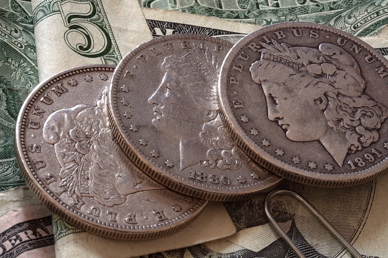 four pieces of coin on some money, sitting on top of a pile of other bills