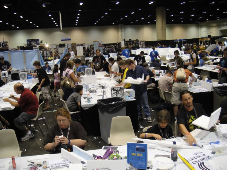 people are gathered around tables with lots of paper and papers