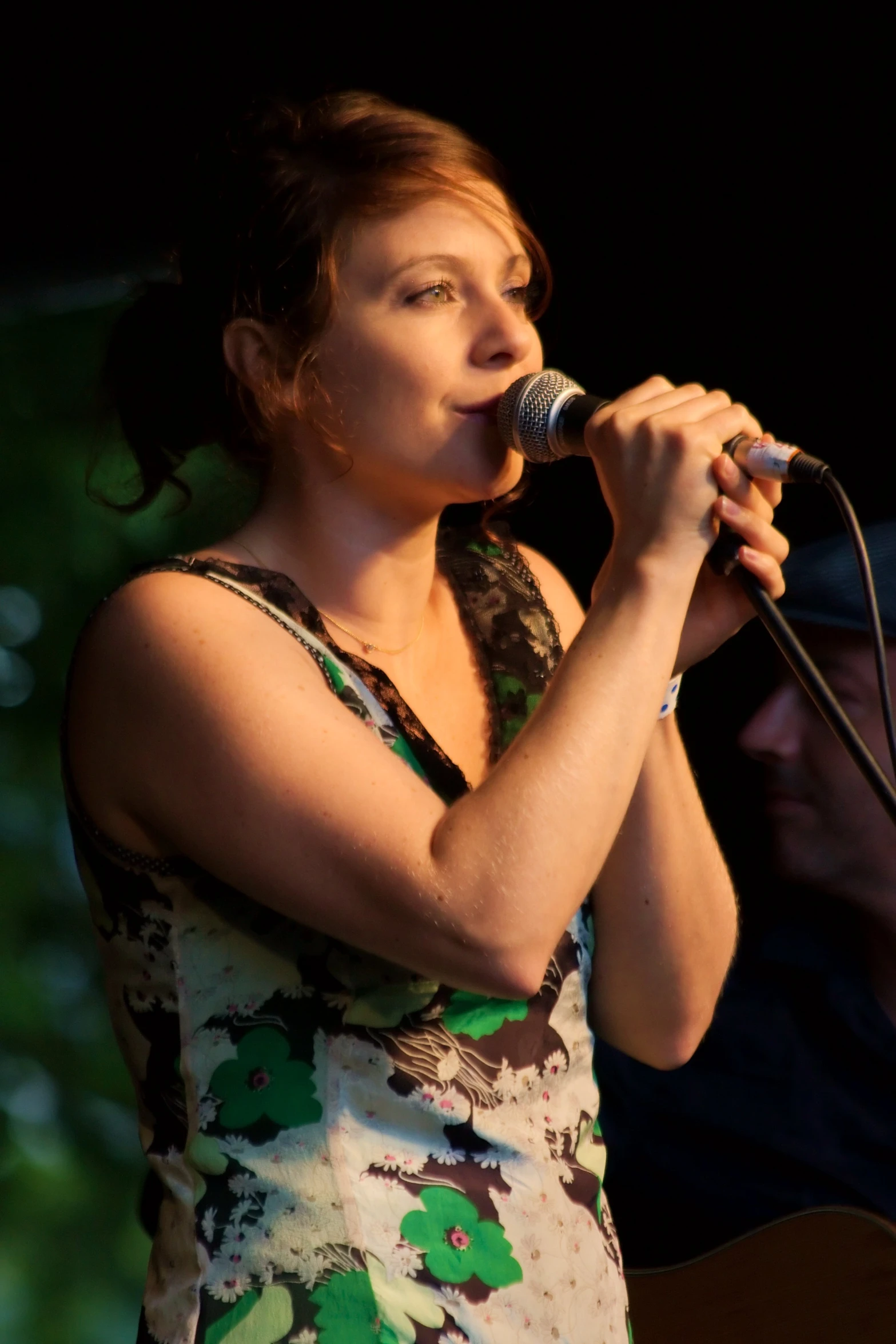 a woman standing up with a microphone in her hand