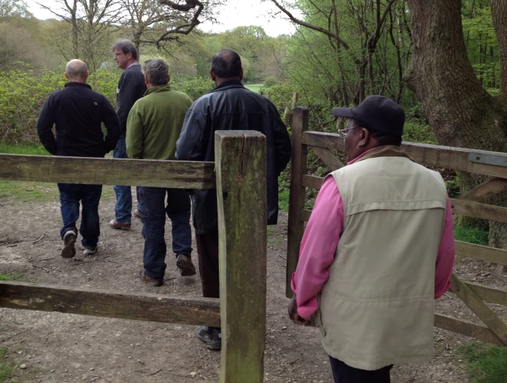 people are walking by a fence on a path