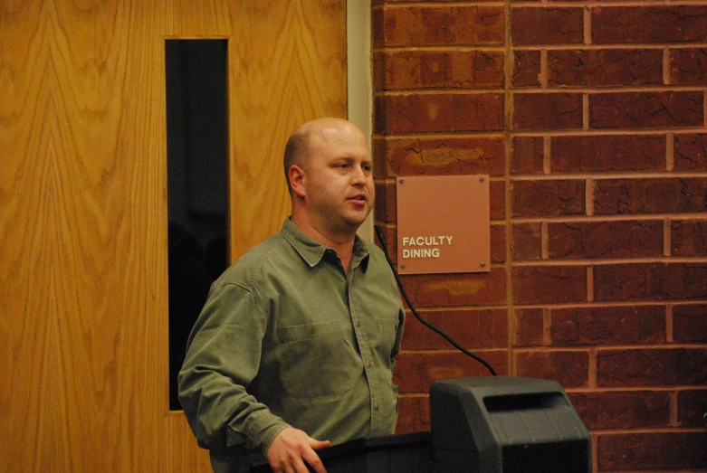 a man standing in front of a sign at a podium