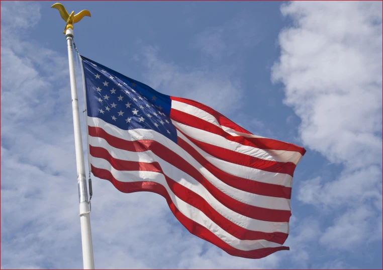 an american flag is flown with a blue sky background