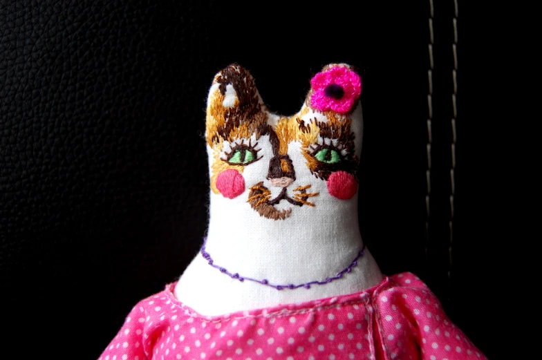 an adorable doll cat wearing pink polka dots