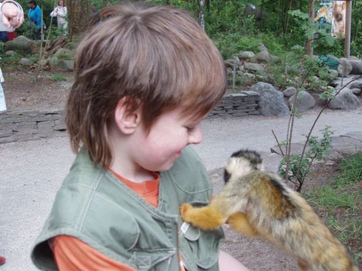 a  is looking at a squirrel on his fingers