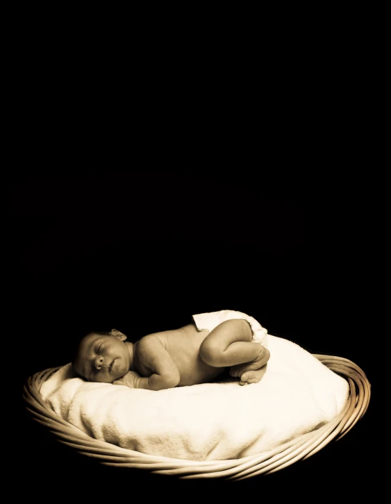 a baby on a white blanket on top of a black floor