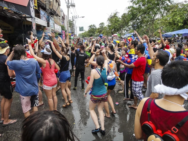 a large group of people walk down a city street in front of each other