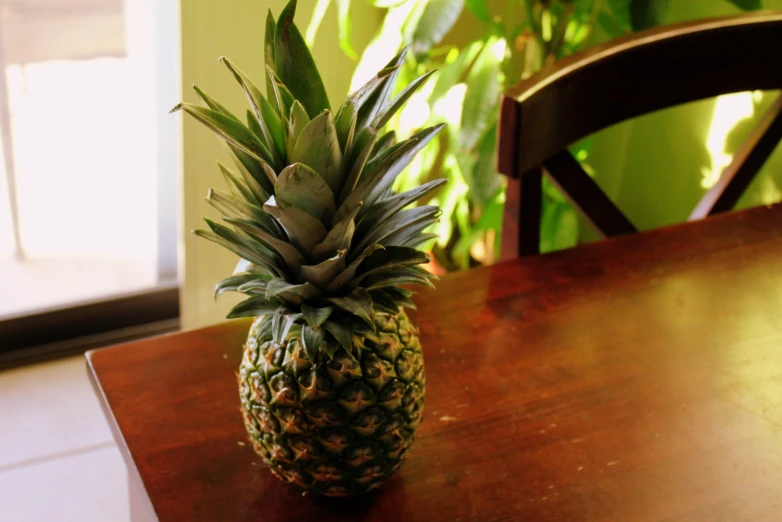 the pineapple is sitting on top of the wooden table