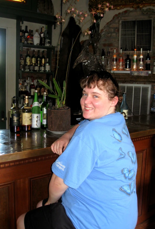 the person is sitting at the bar posing for the camera