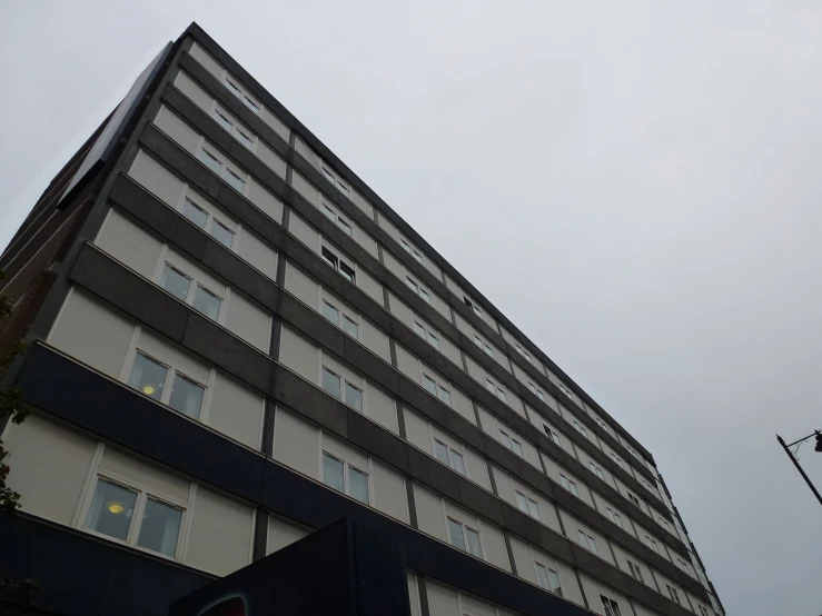 there is a very tall building that is under a cloudy sky