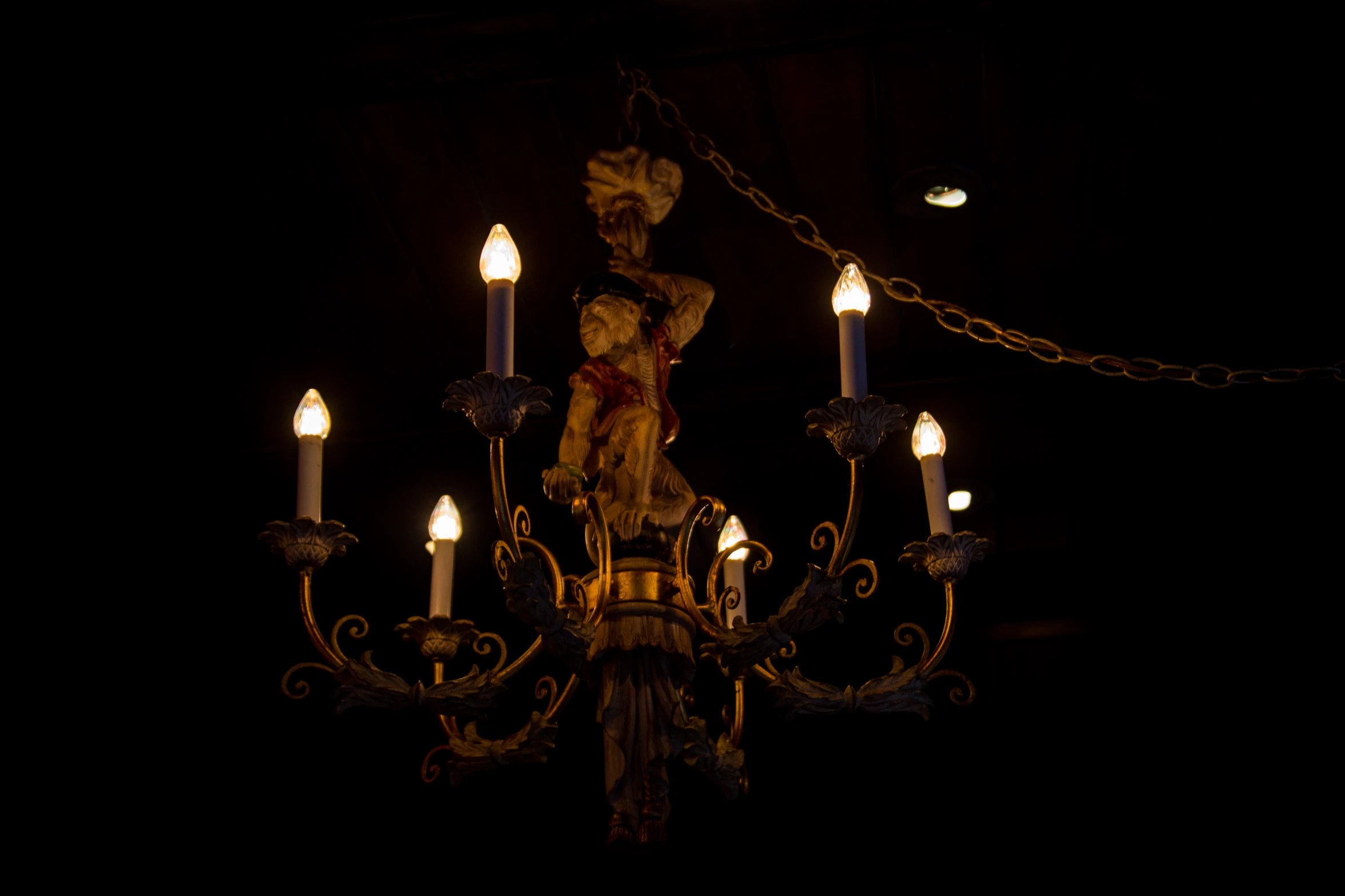 lit chandelier and candles in dim lighting at night