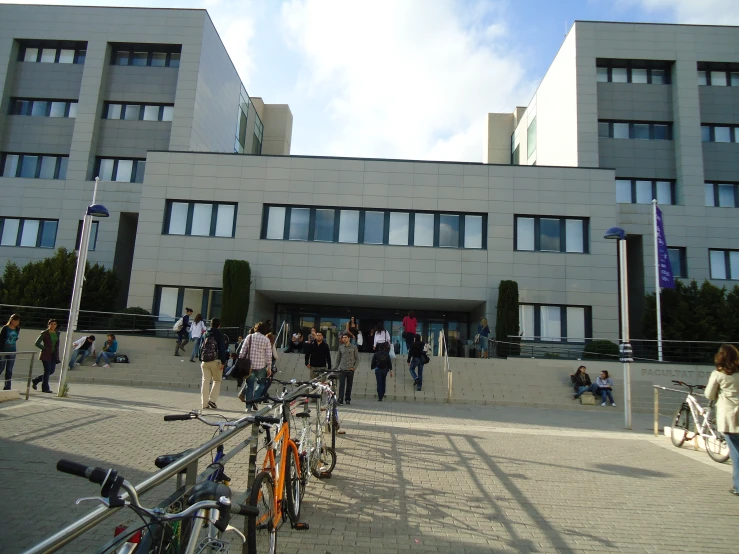 several bicycles parked in front of a gray building