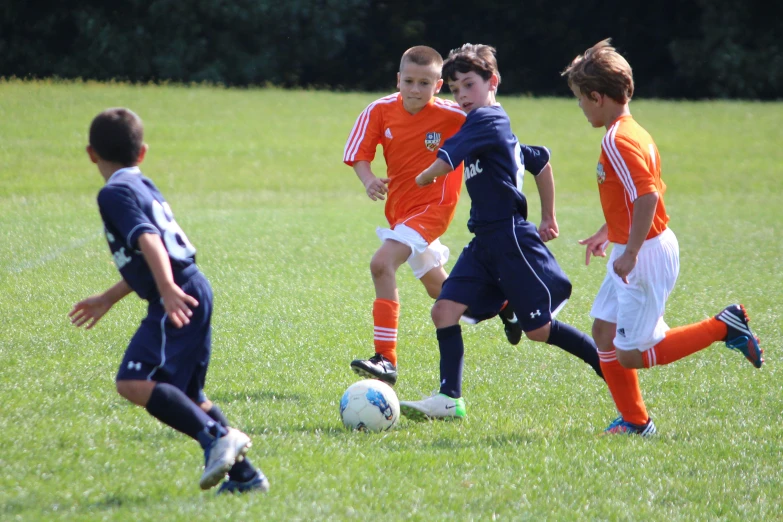 four s kicking a soccer ball around