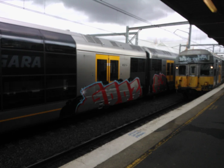 two trains are passing side by side on the tracks