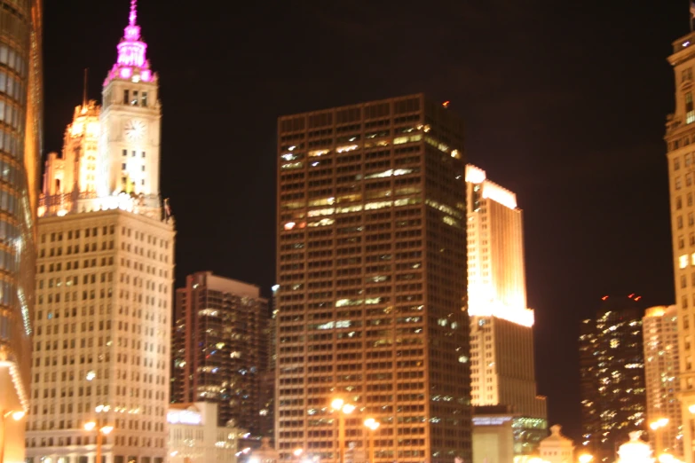 a group of tall buildings stand illuminated in the dark