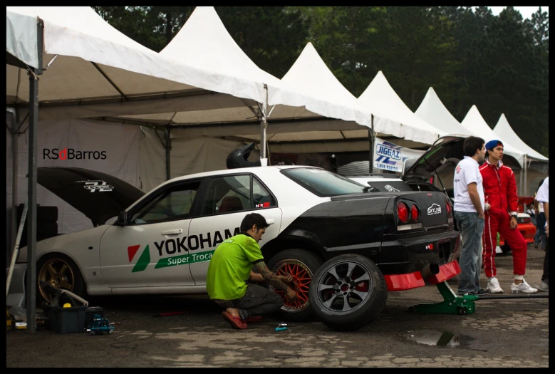 the man in the green shirt is fixing the tire