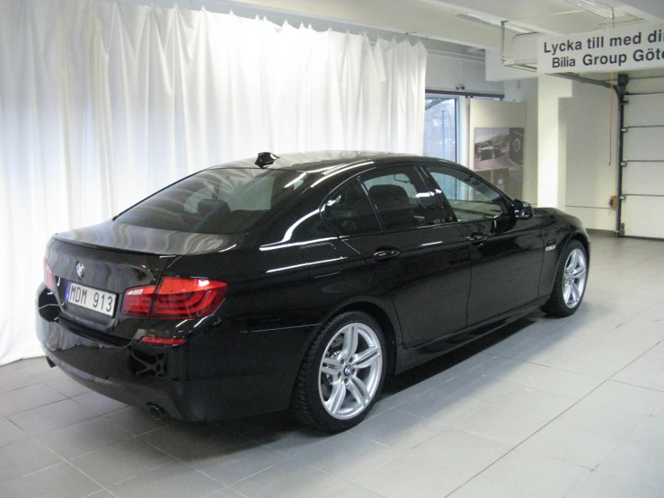 the back end of a black car in a large room