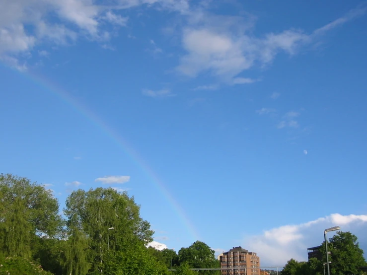 a double rainbow and some tall buildings on a sunny day