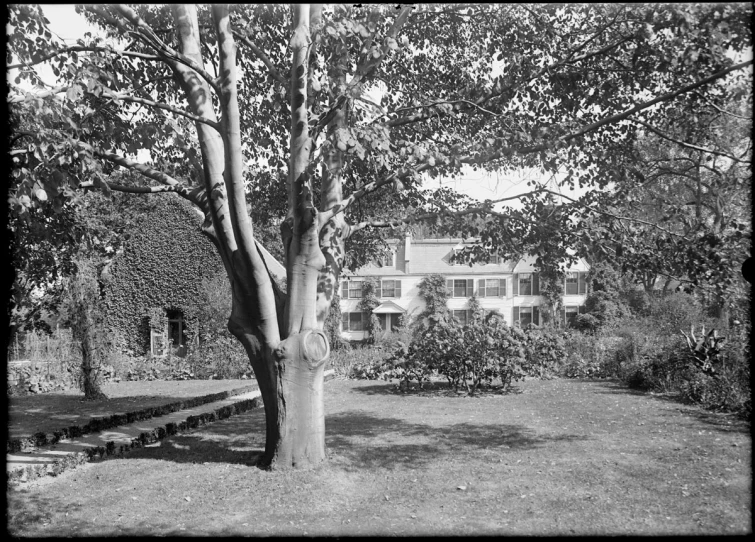 an old home that is surrounded by trees and grass