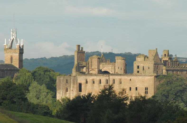 the ruins of a castle stand out against trees