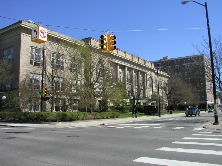 some cars are riding down the road past an old building