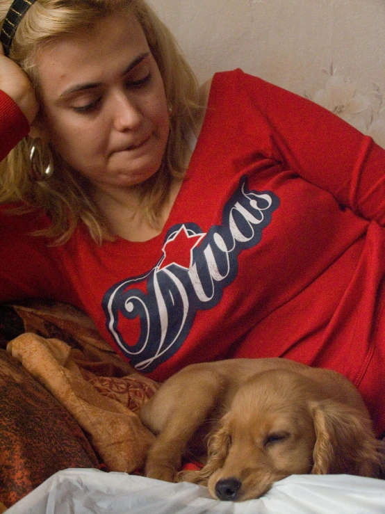 a woman is holding her dog while she lays down