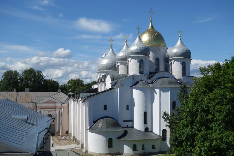 a church with gold domes sits on a hill