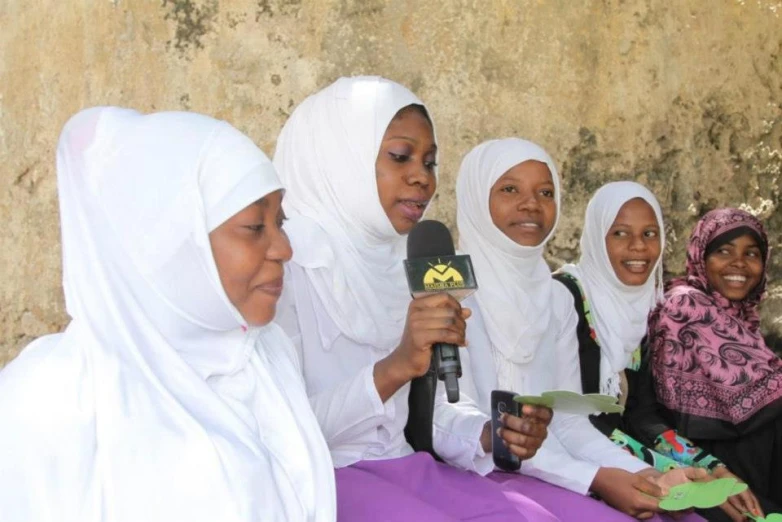 a group of women sit around and look into the camera