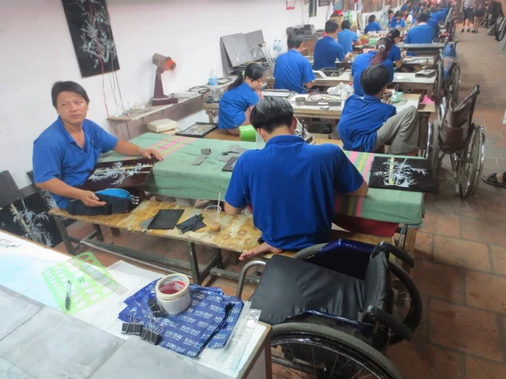 a group of men and women work at tables with bowls on them