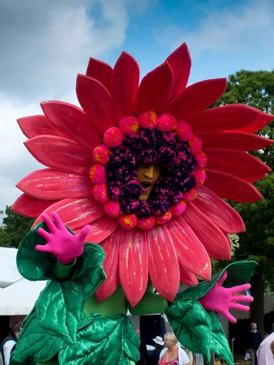 a large pink and green floral decorated balloon sitting on top of a sidewalk