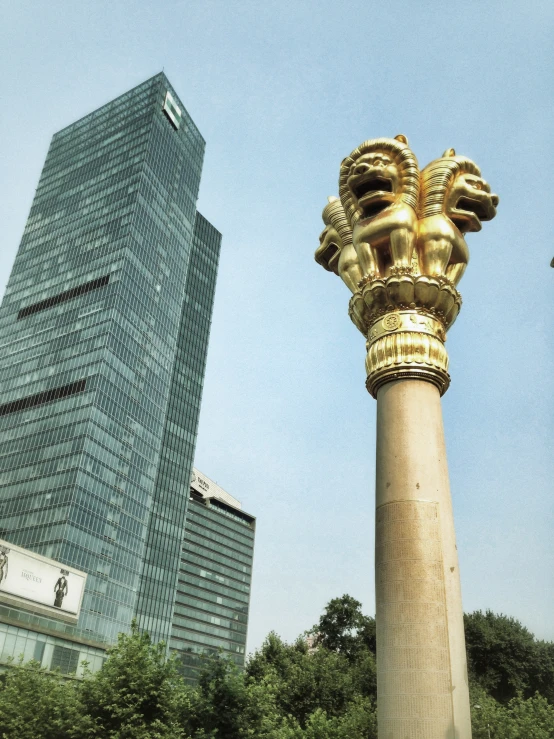 a golden pillar on top of a city street