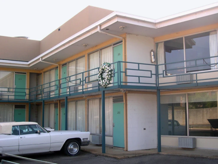 a white car is parked outside of an apartment building