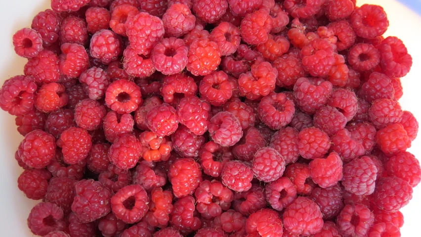 raspberries are being prepared on a platter to be eaten