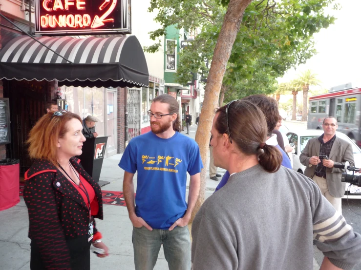 a woman talking to a man on the sidewalk