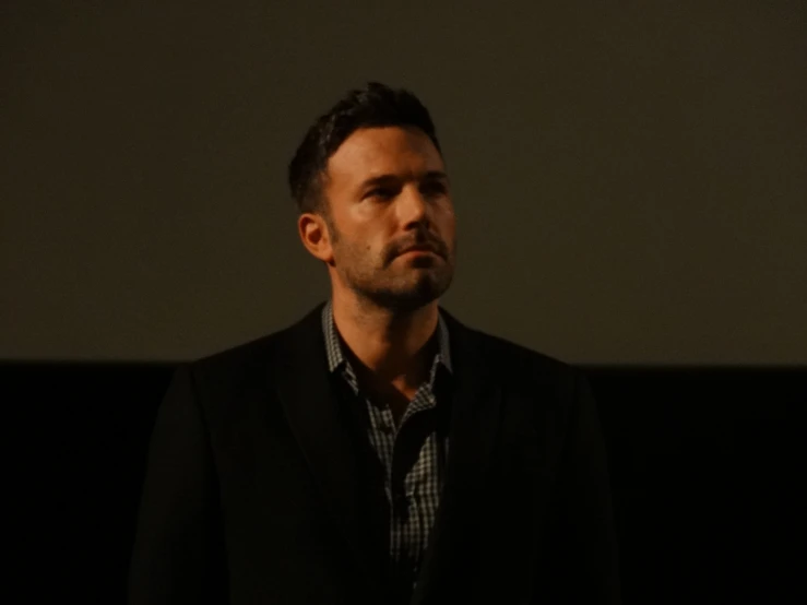 a man that is standing up wearing a suit